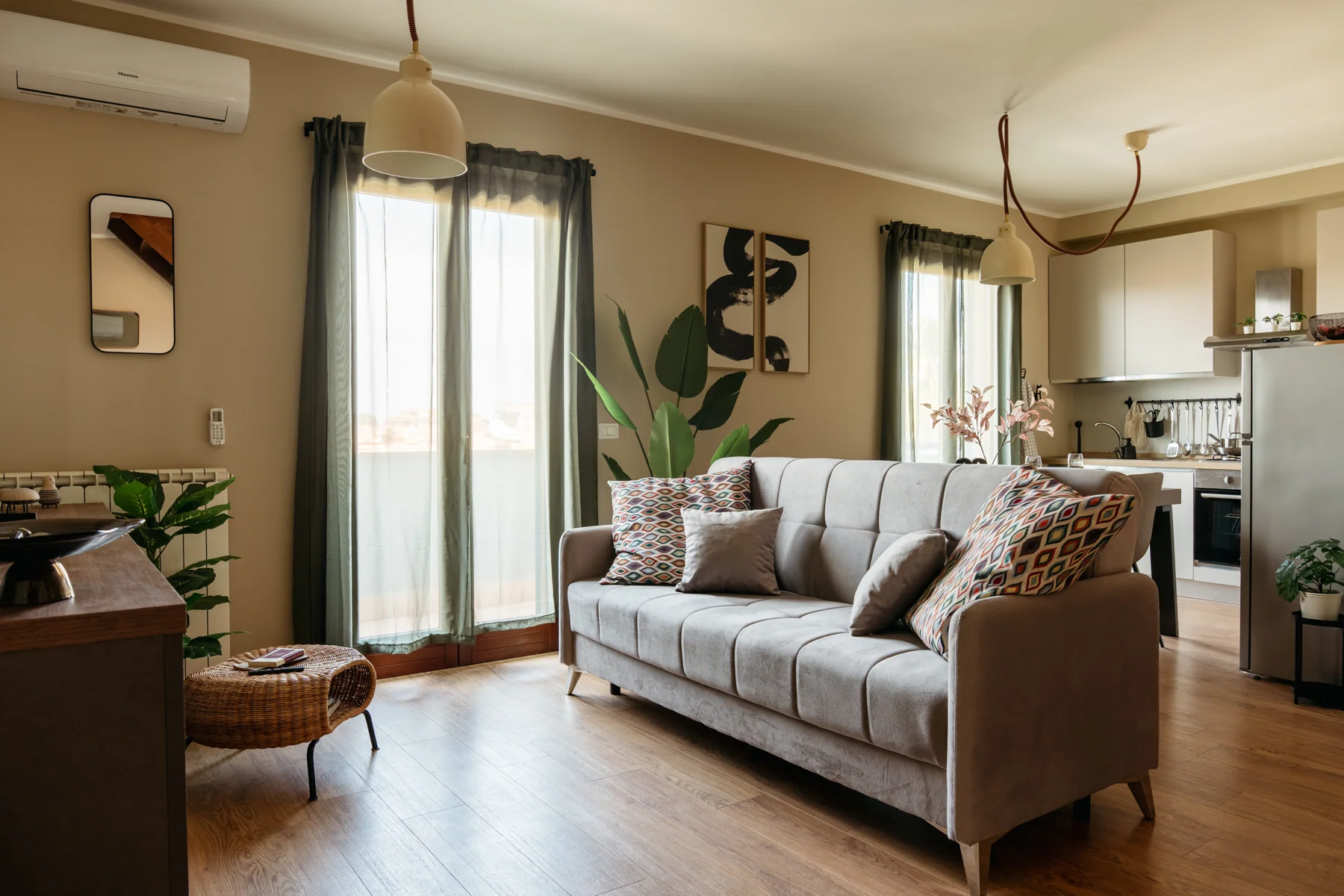 Albero: living room with a grey sofa, French windows and kitchen in the background