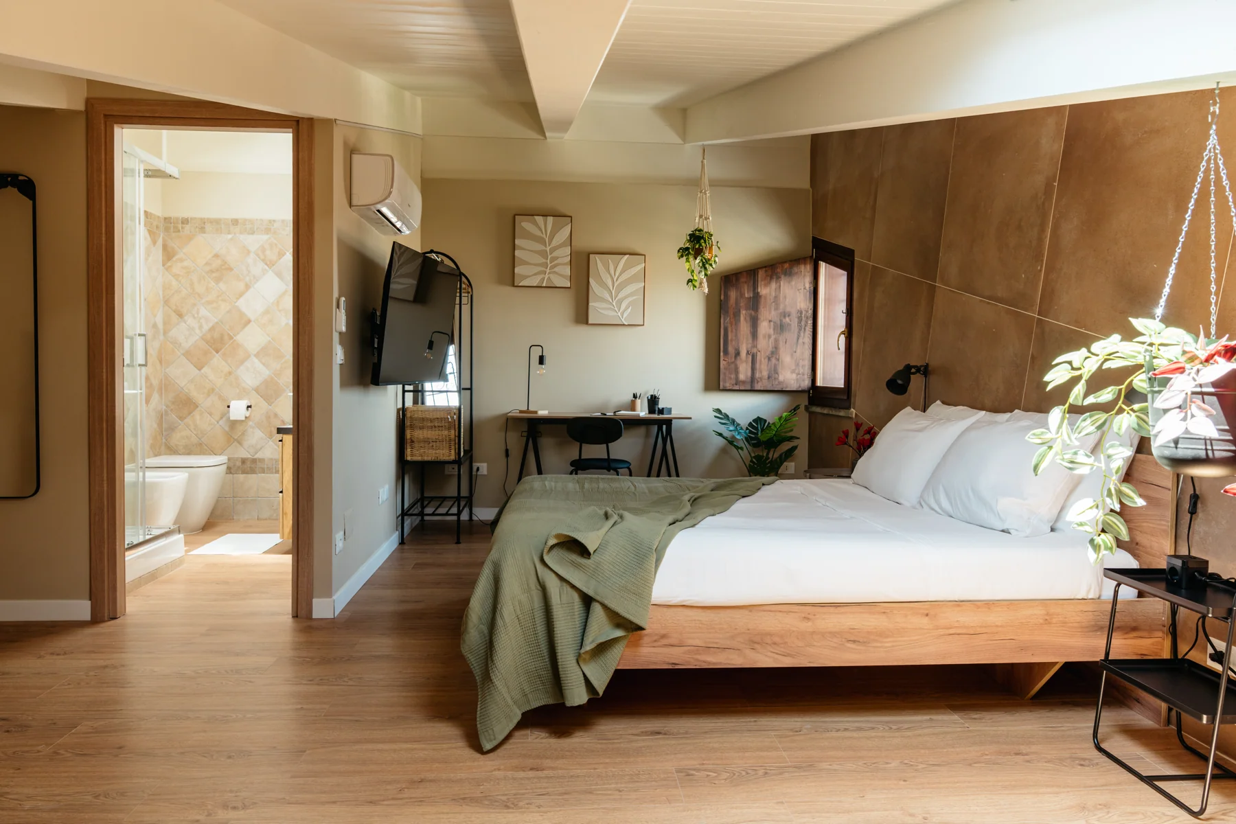 Albero: double bed beneath ceiling beams, beside the bathroom doorway