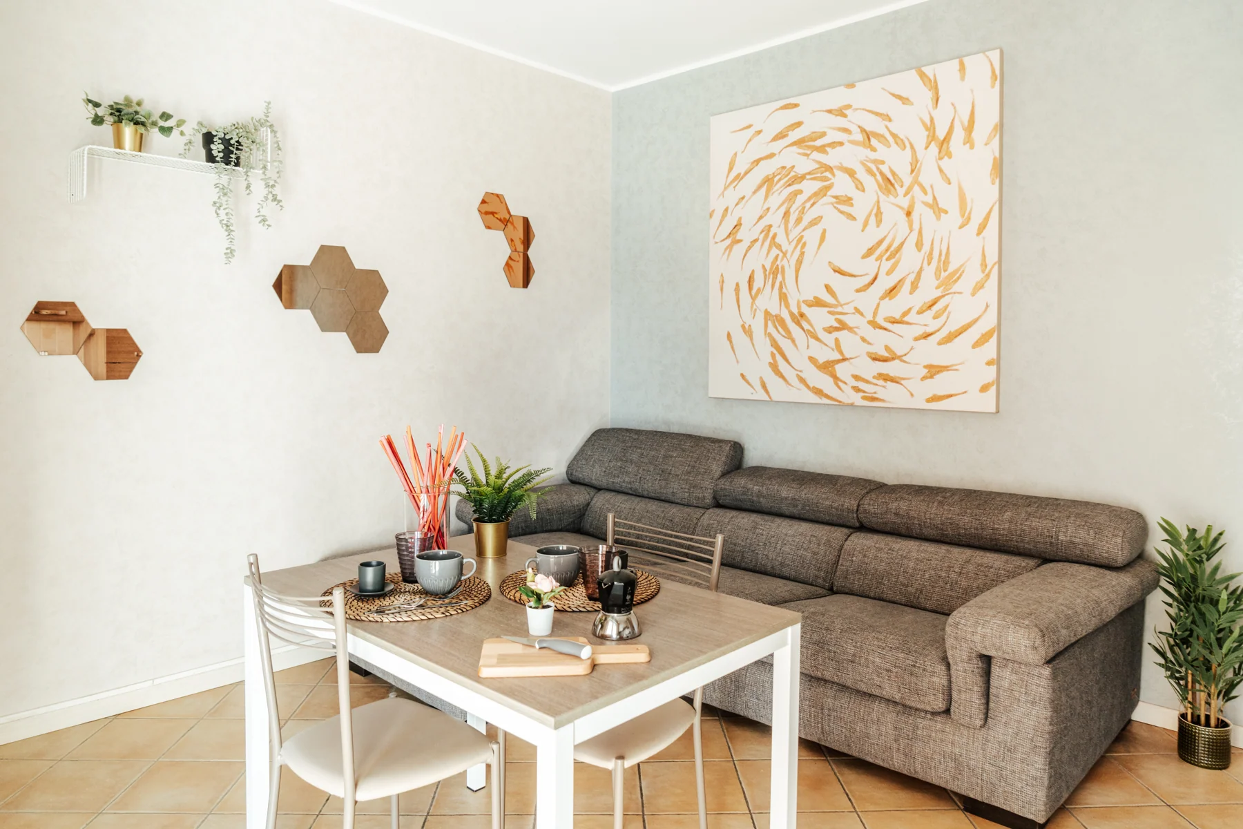 Arancio: living room with a grey sofa, dining table and orange-toned artwork
