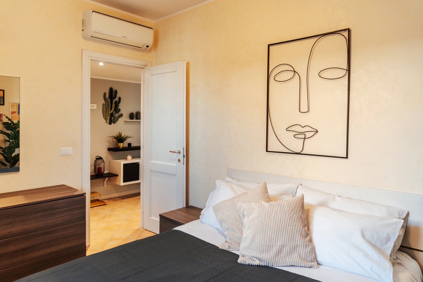 Arancio: double bed beneath a drawing of a stylised face