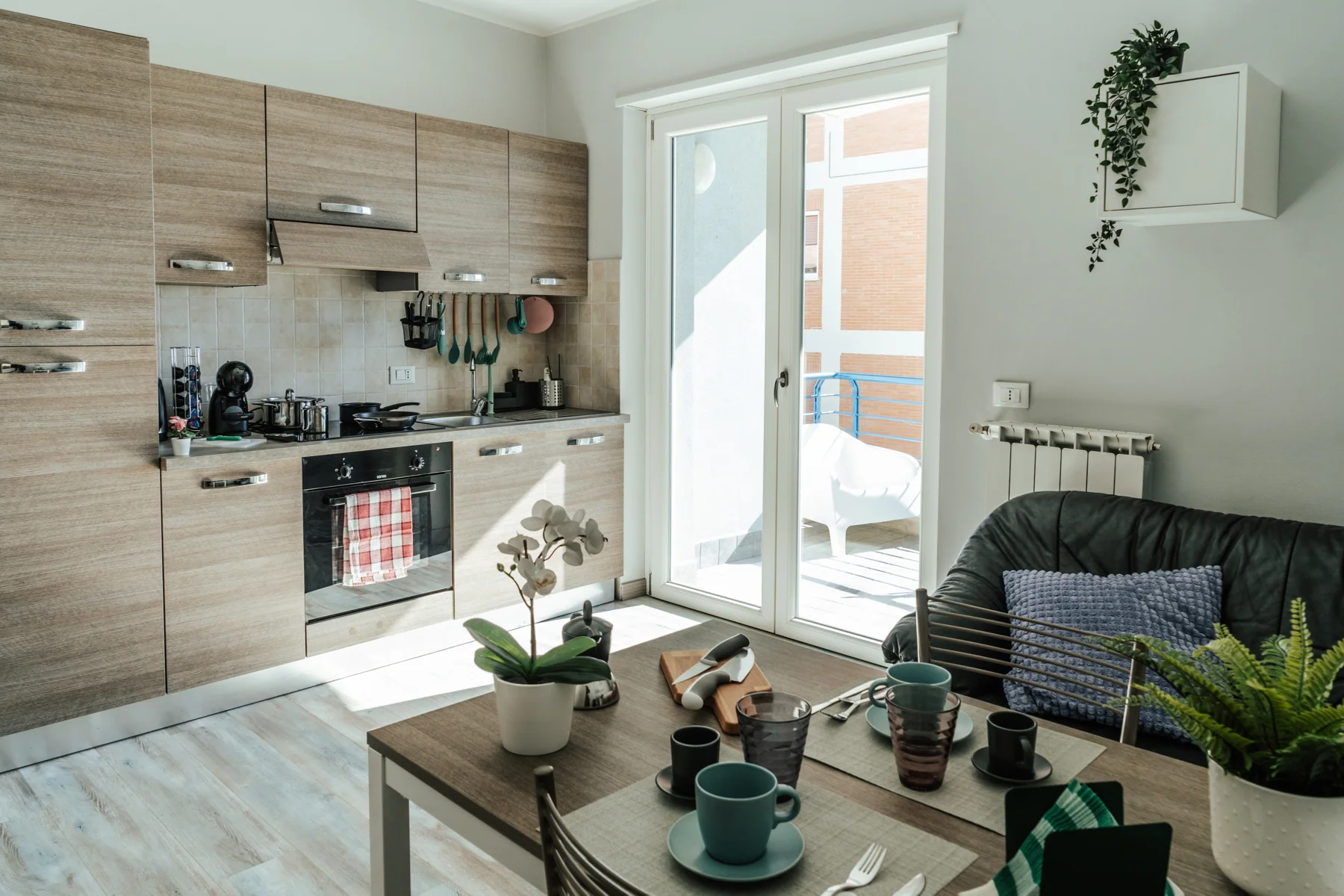Blu: kitchen and dining table, with a sofa beside the balcony door
