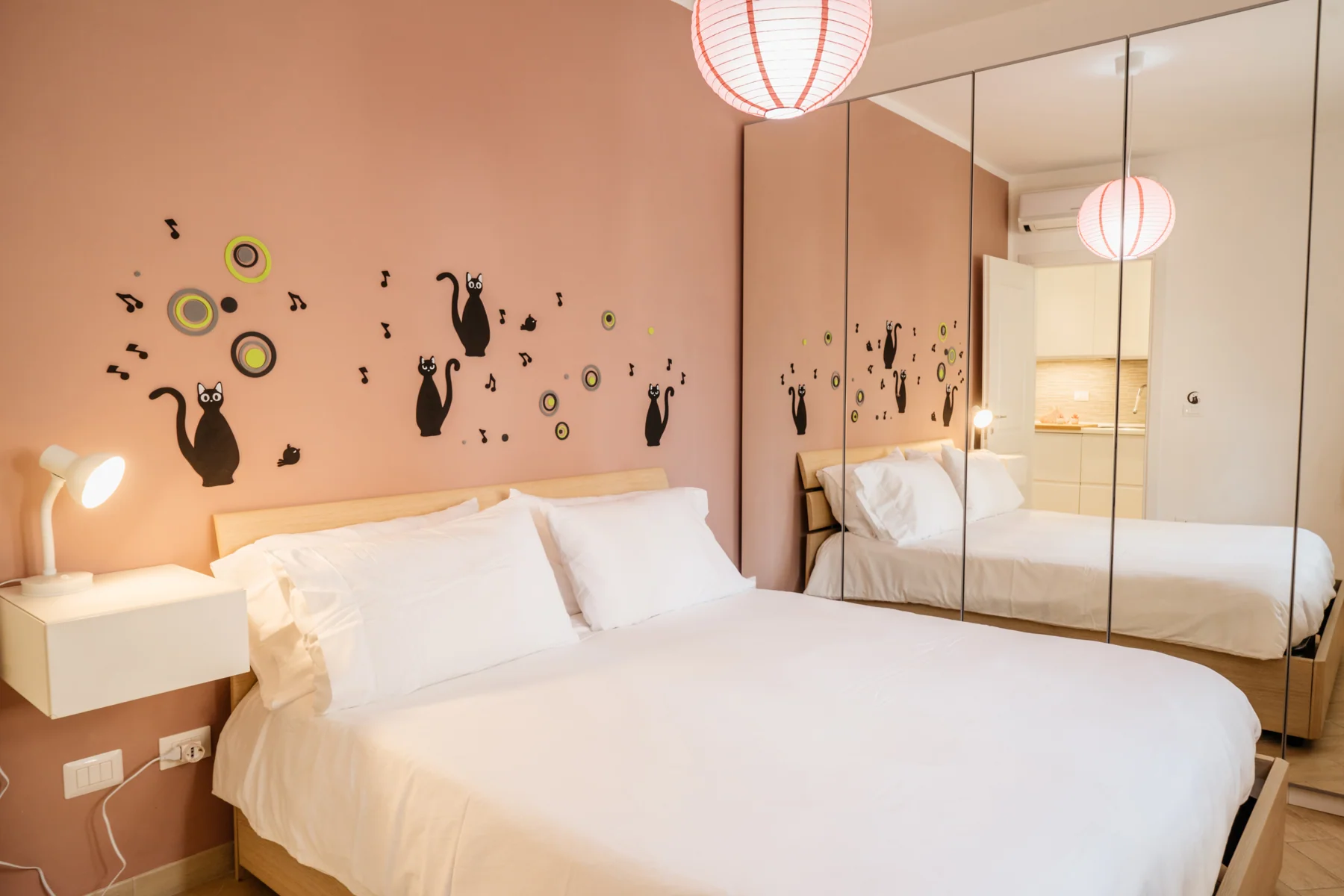 Rosa: bedroom with a double bed, pink wall and mirrored wardrobe