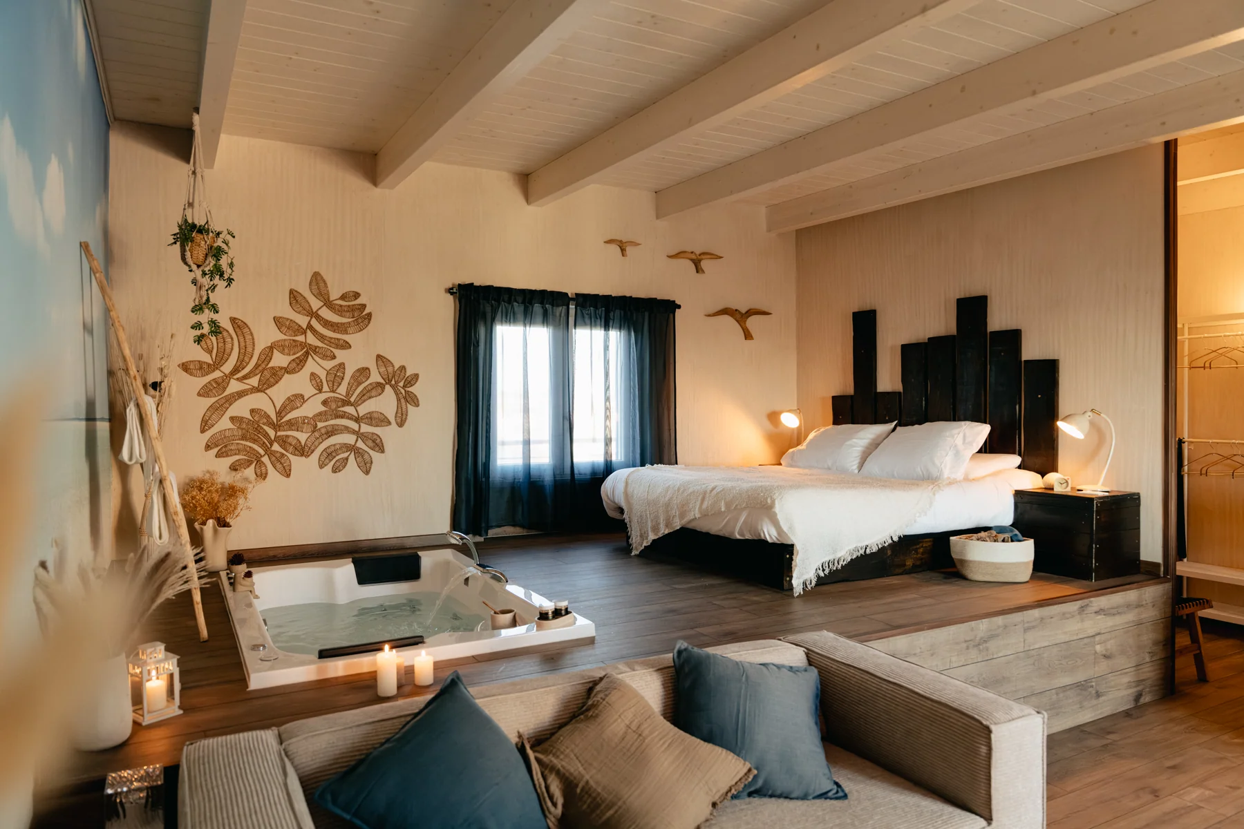 Sabbia: jetted bathtub, double bed and sofa in the open-plan room.