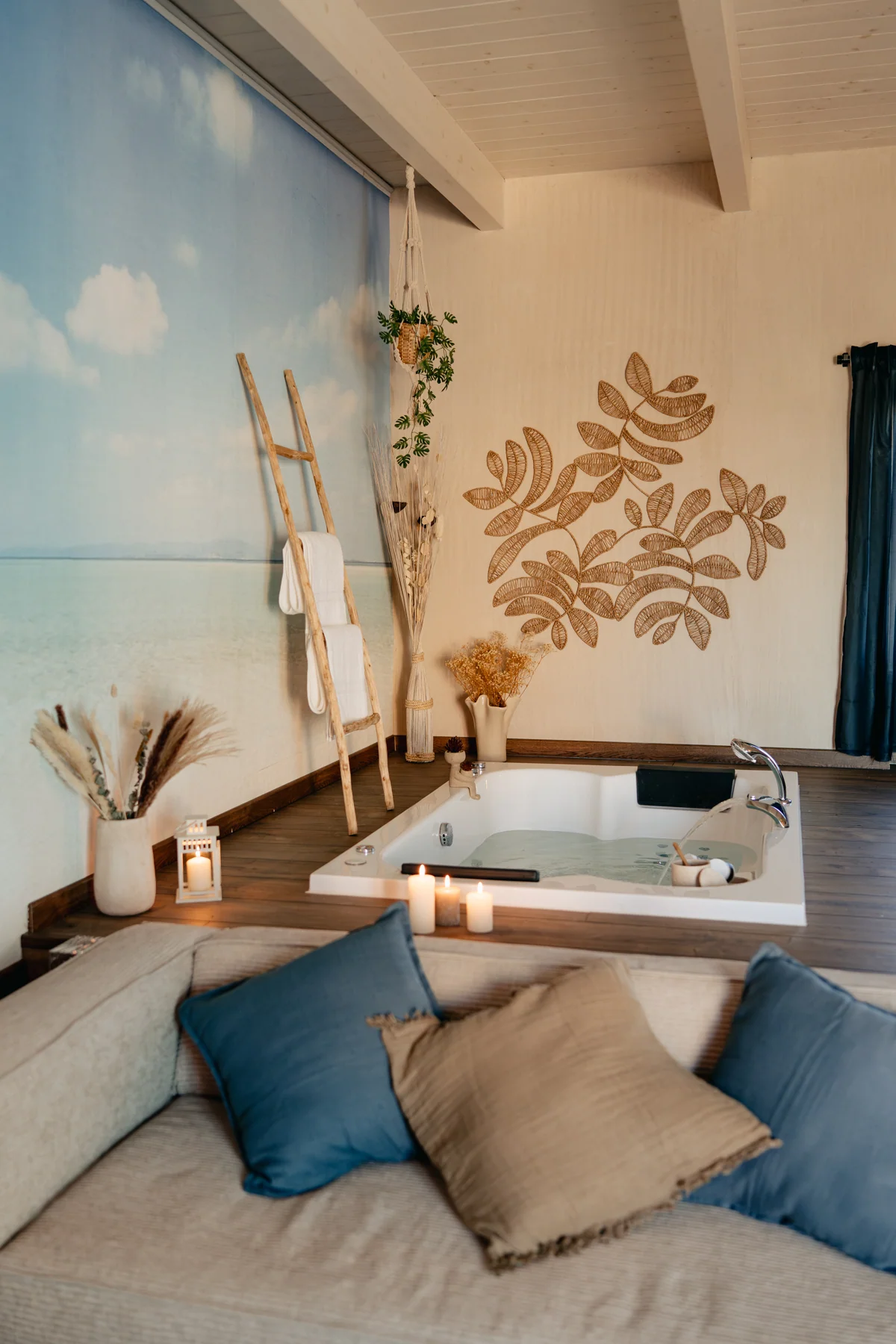 Sabbia: sofa with cushions and a jetted bathtub in the background.
